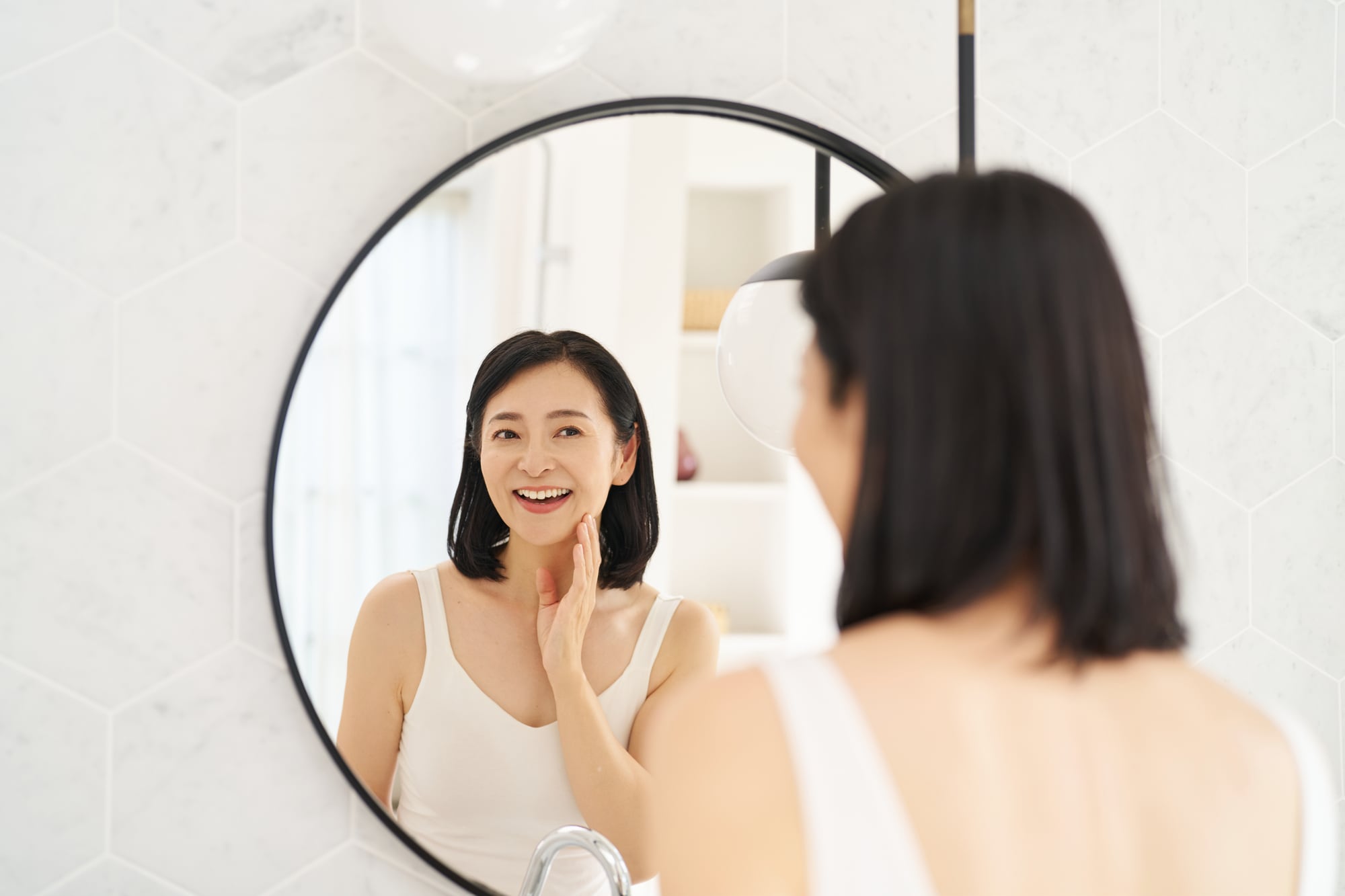 ガミースマイルを治すために笑い方の練習をする女性